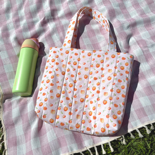 Patterned tote bag with a green bottle on a checkered fabric background