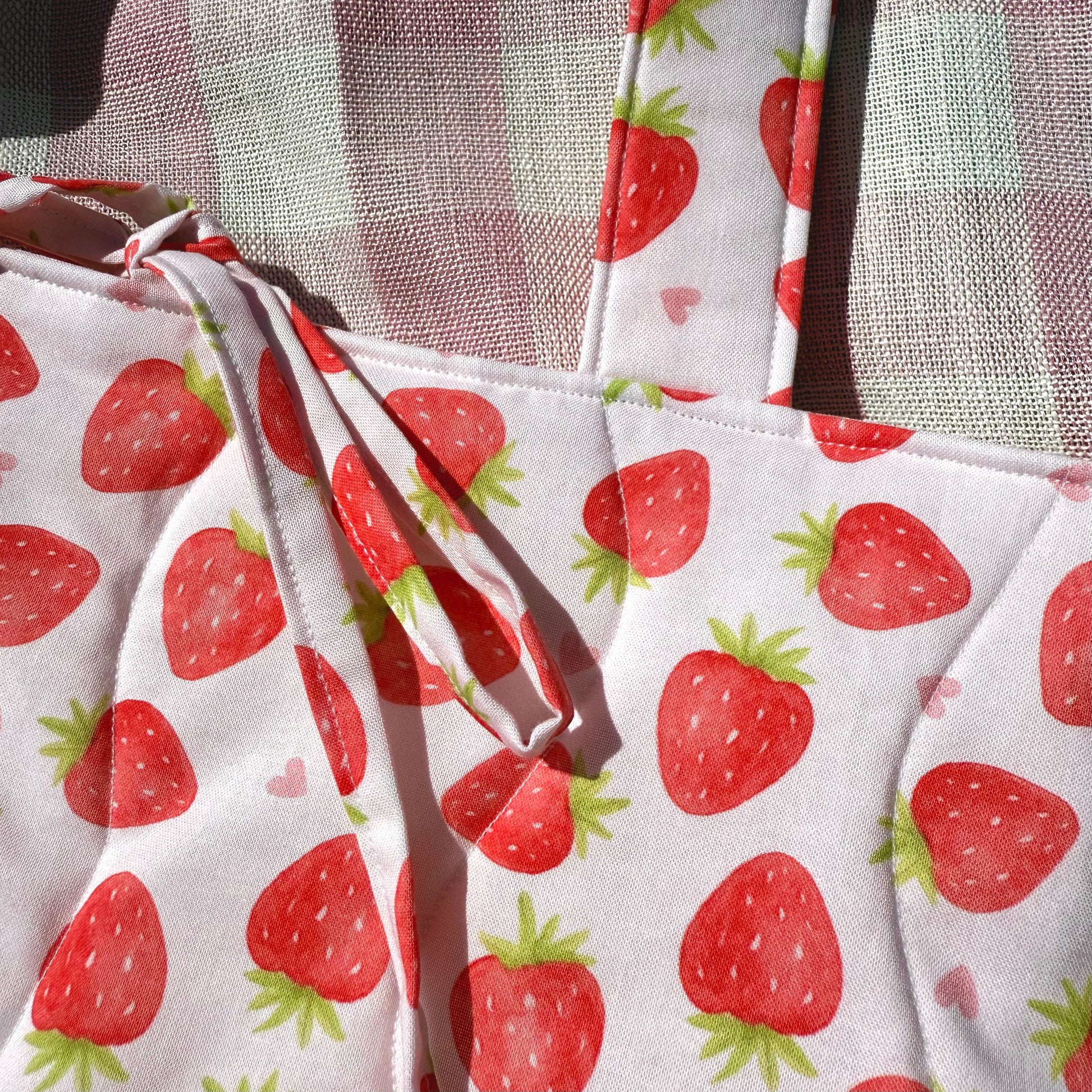 Close-up of strawberry print cotton fabric and pink gingham straps from the Strawberry Love tote bag by From Aly, showcasing premium handmade quality.
