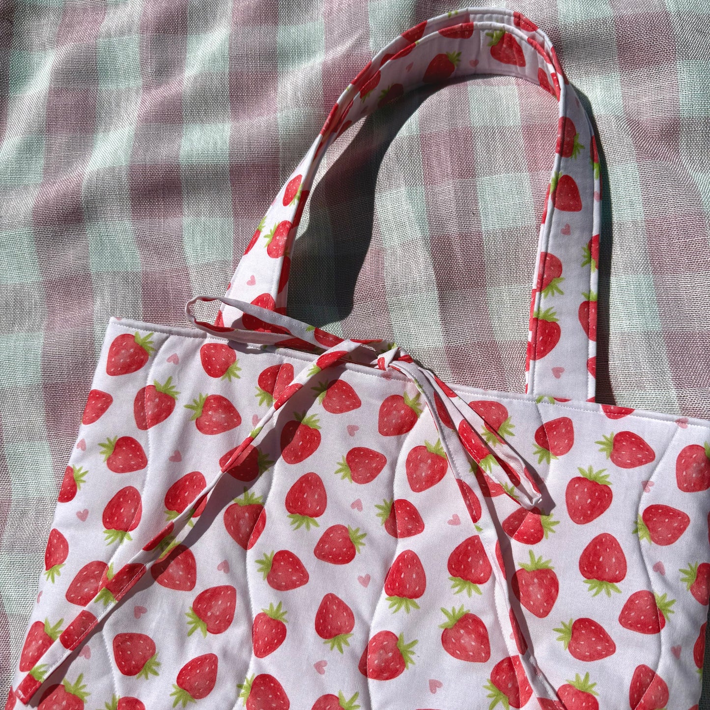 Tote bag with strawberry pattern on a checkered fabric background